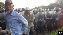 Villagers stand next to riot police deployed to Vietnam's northern Hung Yen province during a protest on April 24, 2012. (AP file photo)