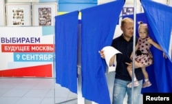 A man leaves a voting cabin at a polling station in Moscow, Sept. 9, 2018.