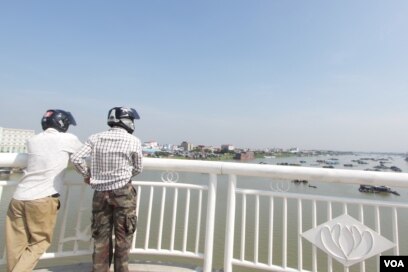 ​អ្នក​ធ្វើ​ដំណើរ​តាមបណ្តោយស្ពាន​ជ្រោយចង្វាថ្មី ចុះចតសង្កេតមើលទិដ្ឋភាព​ផ្ទះ​បណ្តែត​ទឹក​របស់​ប្រជា​នេសាទ​នា​ទិស​ខាងជើង​ស្ពាន ​នៅរាជធានីភ្នំពេញ នៅថ្ងៃទី​ ០២ ខែឧសភា ឆ្នាំ២០១៧។ (ខាន់ សុគុំមនោ/VOA)