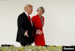 FILE - U.S. President Donald Trump escorts British Prime Minister Theresa May down the White House colonnade after their meeting at the White House in Washington, Jan. 27, 2017.