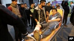 Palestinian medics wheel a wounded youth, who was shot by Israeli troops during a protest at the Gaza Strip's border with Israel, into the treatment room of Shifa hospital in Gaza City, Dec. 7, 2018.