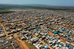 FILE - This April 19, 2020 photo shows a large refugee camp on the Syrian side of the border with Turkey, near the town of Atma, in Idlib province, Syria.