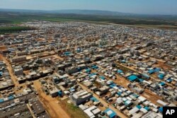 FILE - This April 19, 2020 photo shows a large refugee camp on the Syrian side of the border with Turkey, near the town of Atma, in Idlib province, Syria.