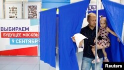 A man leaves a voting cabin at a polling station in Moscow, Sept. 9, 2018. 