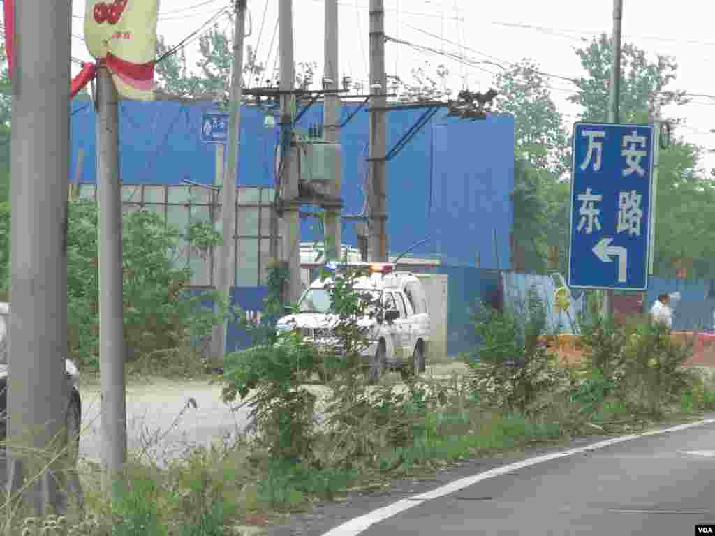 通往北京万安公墓的路口停放着警车。（美国之音东方拍摄）