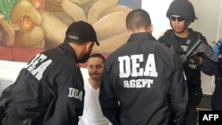 FILE - Agents of the U.S. Drug Enforcement Agency (DEA) listen to an alleged drug trafficker ahead of his extradition to the United States, in Tegucigalpa, Honduras, April 26, 2019 (Honduras Military Police handout).
