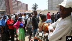 FILE: Customers wait in a queue to withdraw cash from a bank in Harare, Zimbabwe, after the Reserve Bank of Zimbabwe issued new banknotes, Tuesday, Nov, 12, 2019. (AP Photo/Tsvangirayi Mukwazhi)