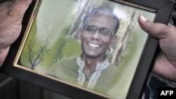 A man holds a portrait of Bangladeshi professor Rezaul Karim Siddique, who was hacked to death by unidentified attackers, in Rajshahi on April 23, 2016. 