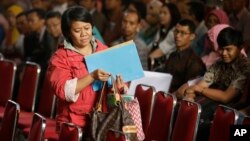 An Indonesian woman carrying documents registers her earnings for the government's tax amnesty at the tax office in Jakarta, Indonesia, in Jakarta, Indonesia, Sept. 29, 2016. (AP Photo/Achmad Ibrahim)