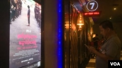 A movie-goer is checking his phone await the screening of “First They Killed My Father” at Major Cineplex Cinema, Phnom Penh, Cambodia, on September 21st, 2017. (Khan Sokummono/VOA Khmer) 