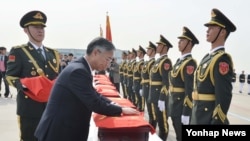 31일 인천국제공항에서 열린 중국 군 유해인도식에서 추궈홍 중국대사가 유해 봉안함에 오성홍기를 감싸고 있다. 한국 국방부는 이날 6.25 전쟁 중국군 전사자 36구의 유해를 중국에 인도했다.