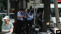 FILE - Policemen officers prepare for their duty on a street near the Jingxi Hotel where the Communist Party's 205-member Central Committee is holding its third plenum in Beijing, July 15, 2024.