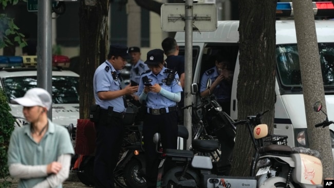 FILE - Policemen officers prepare for their duty on a street near the Jingxi Hotel where the Communist Party's 205-member Central Committee is holding its third plenum in Beijing, July 15, 2024.