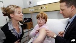 FILE - Ami-Louise Cochrane, center, receives a flu vaccination at Flinders Medical Center, in Adelaide, Australia. 