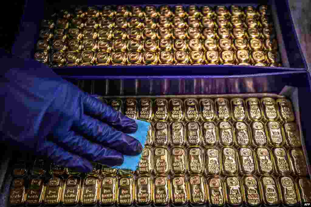 A worker cleans gold bullion bars at the ABC Refinery in Sydney, Australia. Gold prices hit $2,000 an ounce on markets for the first time, the latest price rise.