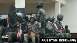 FILE: Police men sit on a truck as they patrol in Akwa, Anambra State in southeast Nigeria, on November 3, 2021. 