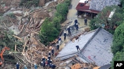 An aerial view of rescue workers searching for missing people among the debris of houses destroyed in Tanabe, Wakayama Prefecture, September 5, 2011.