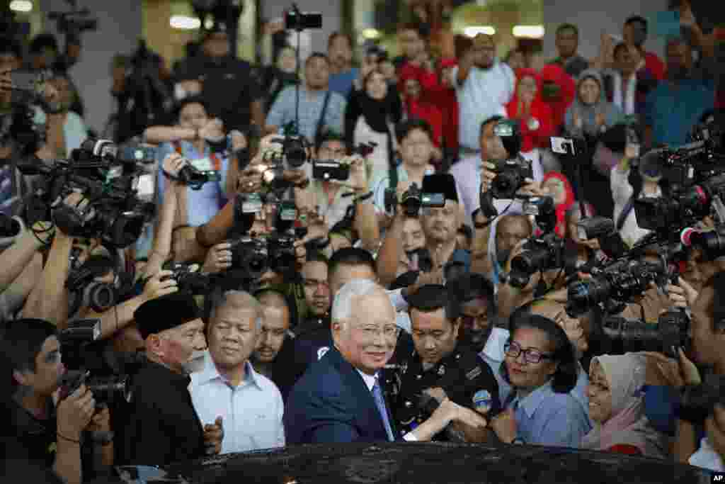 Mantan PM Malaysia Najib Razak (tengah), bergegas masuk ke mobilnya seusai tampil di sidang Pengadilan Tinggi di Kuala Lumpur.&nbsp;