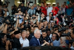 Former Prime Minister Najib Razak, center, gets into a car after his court appearance at the Kuala Lumpur High Court in Kuala Lumpur, Malaysia, Wednesday, April 3, 2019.