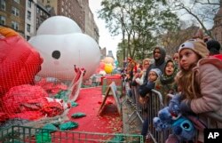 Crowds gather to see giant character balloons being inflated the night before their appearance in the 92nd Macy's Thanksgiving Day parade, Nov. 21, 2018, in New York.