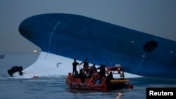 Maritime police search for missing passengers in front of the South Korean ferry "Sewol" which sank at the sea off Jindo, Apr. 16, 2014. 