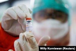 Seorang nakes memegang satu dosis vaksin di sebuah fasilitas kesehatan saat Indonesia memulai vaksinasi COVID-19 untuk para petugas kesehatan di Jakarta, 14 Januari 2021. (Foto: REUTERS/Willy Kurniawan)
