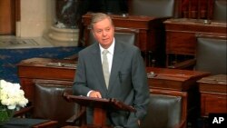 In this image from Senate Television, Sen. Lindsey Graham, R-S.C., speaks on the Senate floor at the Capitol in Washington, Aug. 28, 2018, next to the desk of Sen. John McCain, R-Ariz., draped in black with a bowl of white roses sitting on it.