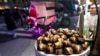 Chestnuts are displayed at a food vendor as a person dressed as Santa Claus offers rides, Thursday, Dec. 12, 2024, in New York. (AP Photo/Alyssa Goodman)