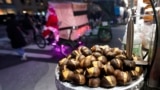 Chestnuts are displayed at a food vendor as a person dressed as Santa Claus offers rides, Thursday, Dec. 12, 2024, in New York. (AP Photo/Alyssa Goodman)