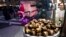 Chestnuts are displayed at a food vendor as a person dressed as Santa Claus offers rides, Thursday, Dec. 12, 2024, in New York. (AP Photo/Alyssa Goodman)