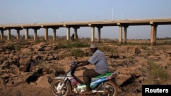 Un homme conduisant sa moto, Bamako, 26 février 2014