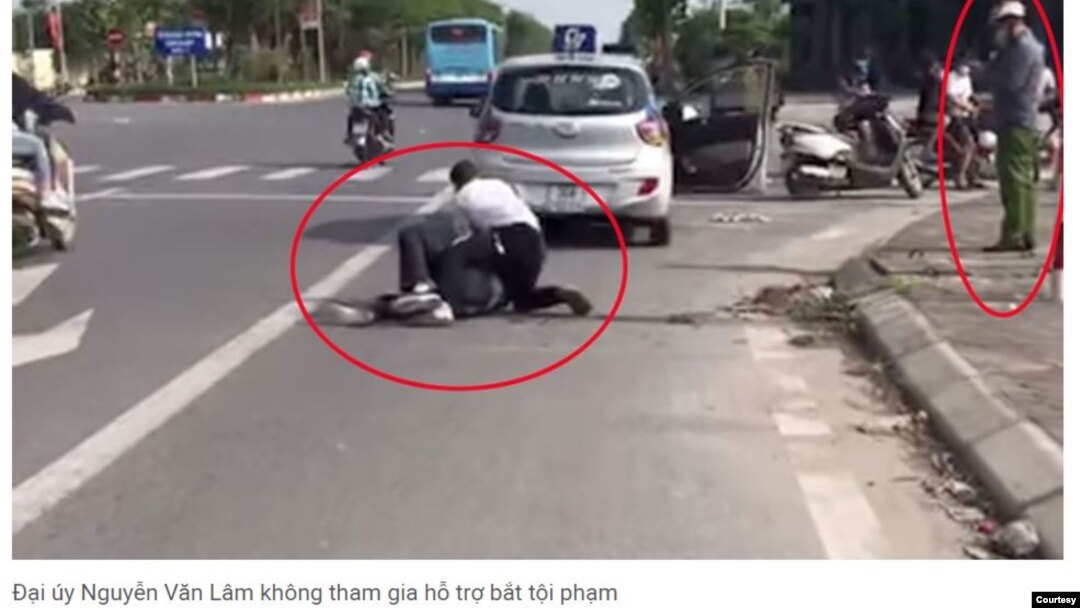 Công an Nguyễn Văn Lâm đứng nghe điện thoại trong lúc vụ cướp xảy ra. Hình: Trích xuất từ báo Thanh Niên.