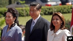 China's President Xi Jinping, center, and his wife Peng Liyuan, left, stand alongside Costa Rica's President Laura Chinchilla as they listen to their national anthems at a welcoming ceremony at the presidential house in San Jose, Costa Rica, June 3, 2013.