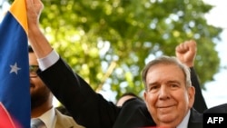 Venezuelan opposition leader Edmundo Gonzalez Urrutia holds a Venezuelan flag as he greets supporters after a meeting with Uruguay's President Luis Lacalle Pou in Montevideo, Uruguay, Jan. 4, 2025.