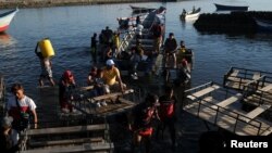 Pasajeros bajan de un bote en el muelle de la ciudad de La Unión, El Salvador, el 20 de agosto de 2022. 