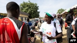 FILE - A member of the Consultation Group Of Political Actors (GCAP) distributes flyers at Dembe market promoting the boycott of Chad's legislative, communal and provincial elections in N'Djamena on Dec. 16, 2024.