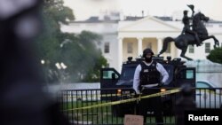 Seorang petugas keamanan federal Secret Service tampak di belakang barikade menghadapi para demonstran yang berunjuk rasa dekat Gedung Putih, di Washington DC, 30 Mei 2020. Mereka memprotes kematian pria Afrika-Amerika George Floyd akibat kebrutalan polis