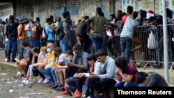 FILE - Migrants from Central America, Haiti and Cuba queue outside the Mexican Commission for Refugee Assistance to apply for asylum and refugee status in Tapachula, Mexico, May 6, 2021.