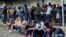 FILE - Migrants from Central America, Haiti and Cuba queue outside the Mexican Commission for Refugee Assistance to apply for asylum and refugee status in Tapachula, Mexico, May 6, 2021.