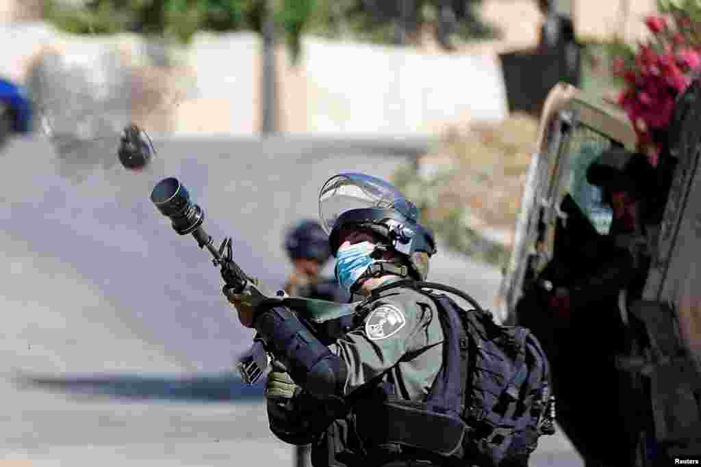 An Israeli border police member fires a tear gas canister toward Palestinians protesting against the demolition of a house under construction by Israeli forces, in Beitunia in the Israeli-occupied West Bank.