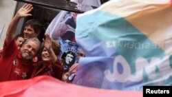 Brazil's President and Workers' Party (PT) presidential candidate Dilma Rousseff (R) and her predecessor Luiz Inacio Lula da Silva wave to supporters during a campaign rally in Sao Paulo, Oct. 3, 2014. 