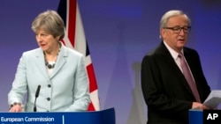 British Prime Minister Theresa May, left, and European Commission President Jean-Claude Juncker prepare to address a media conference at EU headquarters in Brussels on Dec. 8, 2017. 