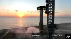 This image provided by SpaceX shows SpaceX's mega Starship rocket upon its return during a test flight, Sunday, Oct. 13, 2024, over Boca Chica, Texas. (SpaceX via AP)