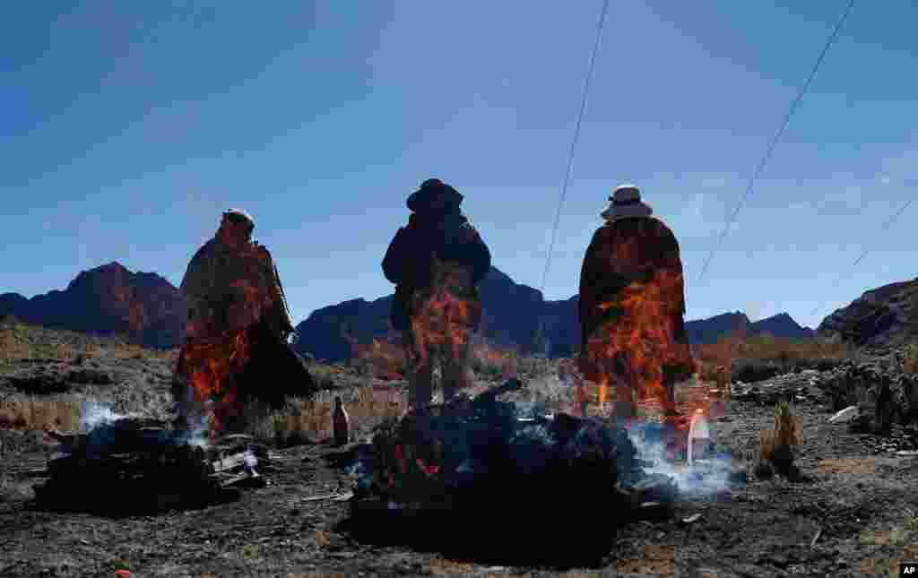 People burn offerings in honor of &quot;Pachamama&quot; or Mother Earth, on La Cumbre, a mountain considered sacred on the outskirts of La Paz, Bolivia, Aug. 1, 2020.
