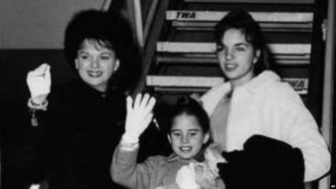 Judy Garland, background, left, waves with her children, Liza, 15, top right, Lorna, 9, center, and Joe, 6, on Jan. 2, 1962, as they were about to board a plane at New York International Airport