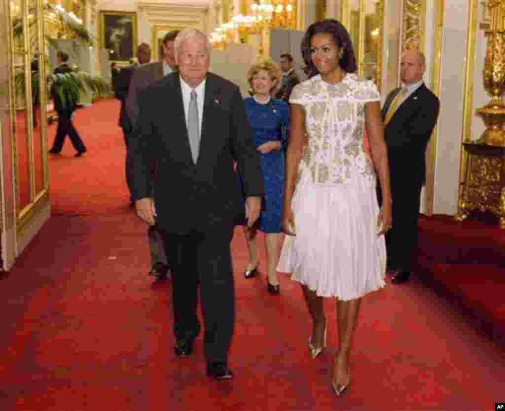 U.S. first lady Michelle Obama and U.S. Ambassador Louis Susman arrive at Buckingham Palace in London for a reception hosted by Queen Elizabeth II for the heads of state and government prior to attending the opening ceremony of the London 2012 Olympic Gam