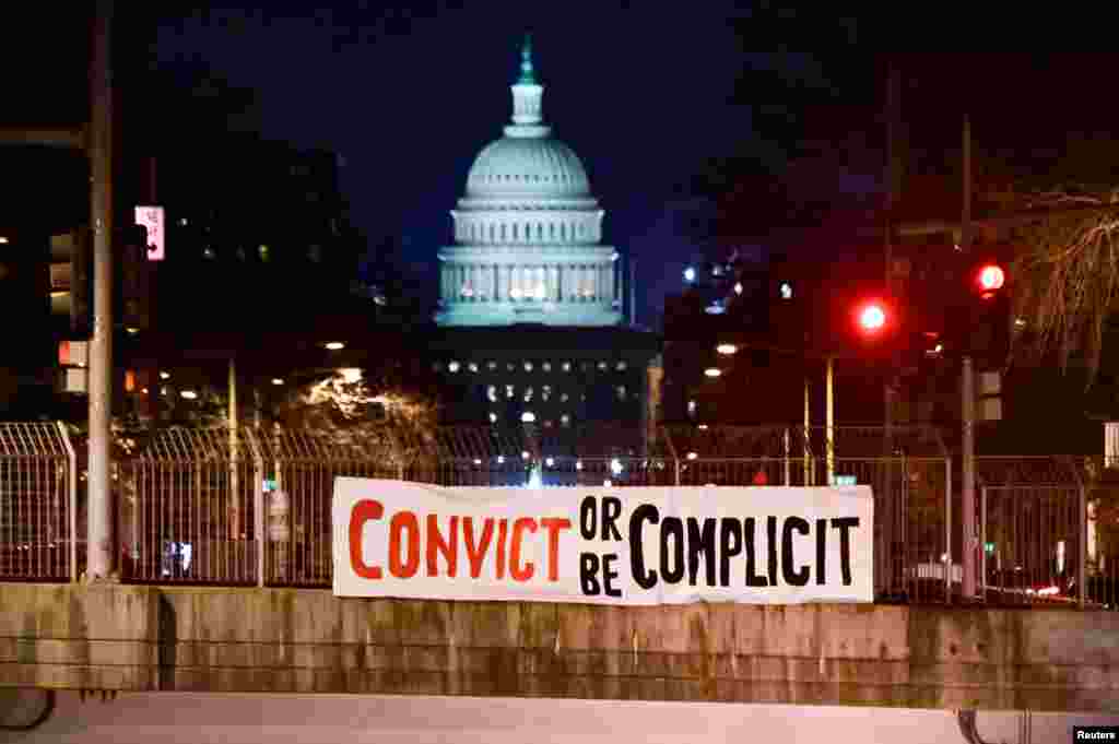 A banner reading, &quot;Convict or be complicit&quot; is hung over a bridge on the first day of the Senate impeachment trial against former President Donald Trump in Washington, D.C., Feb. 9, 2021.