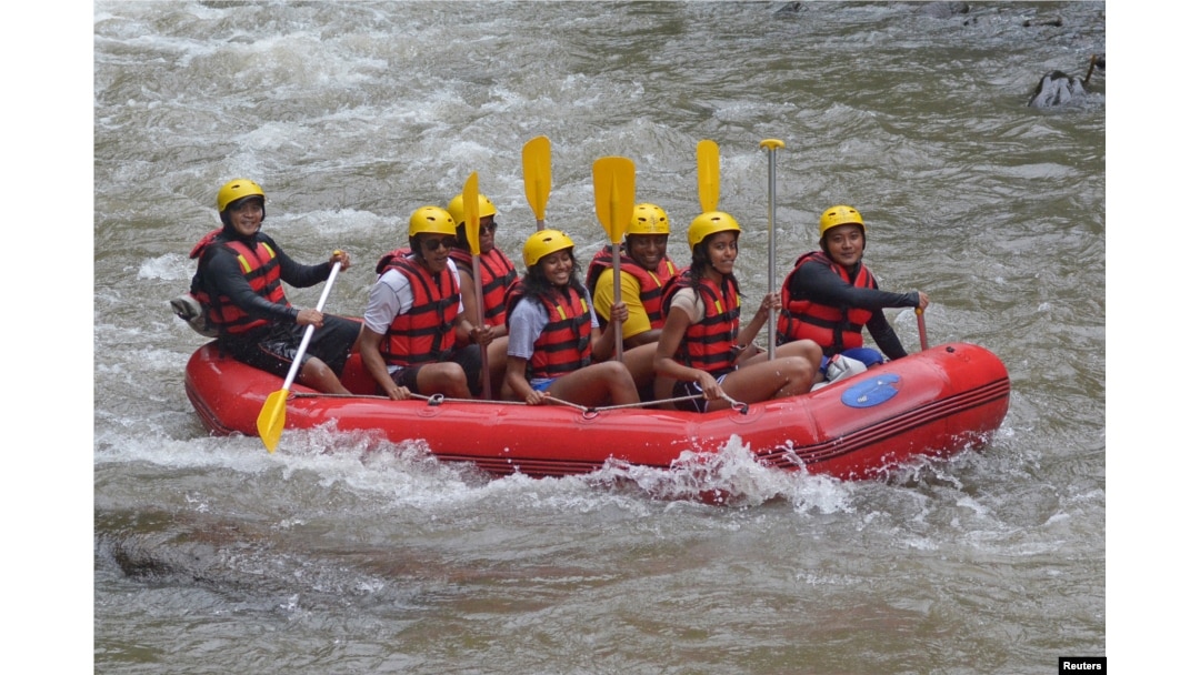 FILE - Former United States President Barack Obama (2nd left), his wife Michelle (3rd left) and with his daughters Sasha (center) and Malia (2nd right) go rafting while on holiday in Bongkasa Village, Badung Regency, Bali, Indonesia, June 26, 2017.