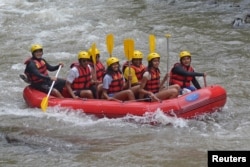 FILE - Former United States President Barack Obama (2nd left), his wife Michelle (3rd left) and with his daughters Sasha (center) and Malia (2nd right) go rafting while on holiday in Bongkasa Village, Badung Regency, Bali, Indonesia, June 26, 2017.