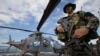 A member of the Philippine Naval Special Operations Group poses for photographers beside the Philippine Navy Agusta Westland 109 helicopter on board the BRP Gregorio Del Pilar (PF15) warship at Manila's pier, Dec. 17, 2014.